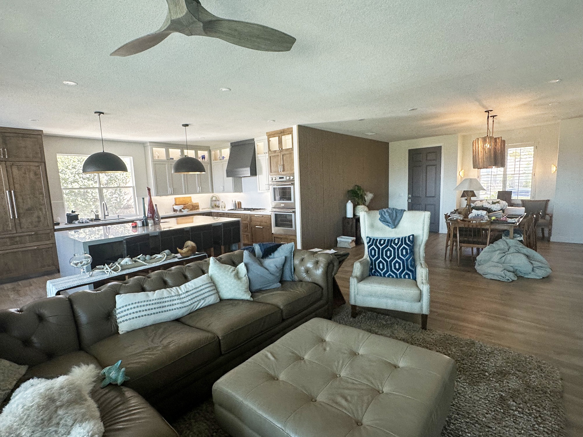 Modern open-concept living space featuring a cozy seating area, sleek kitchen, and dining area. Abundant natural light and stylish decor.